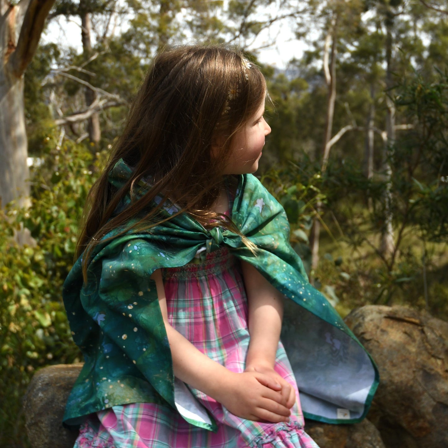 Forest play cloth used as a cape for child during outdoor imaginative play