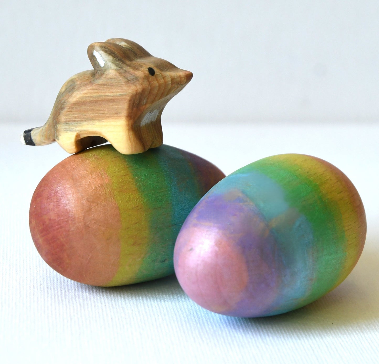 Rainbow wooden musical Easter egg maraca shakers with wooden bilby toy.