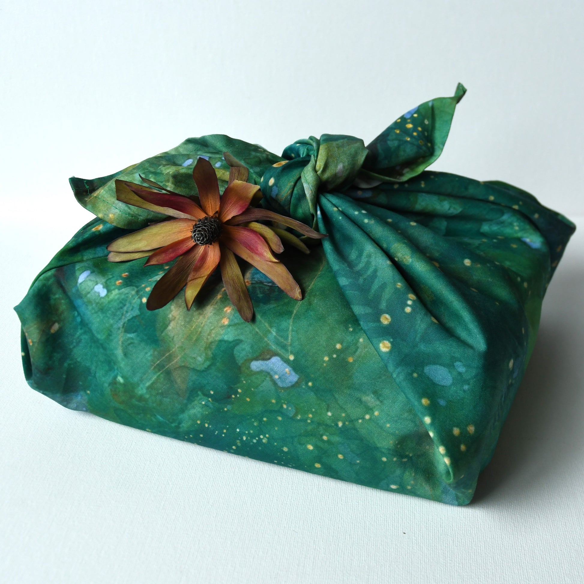 Green forest themed cotton play cloth used as reuseable gift wrap for Christmas.